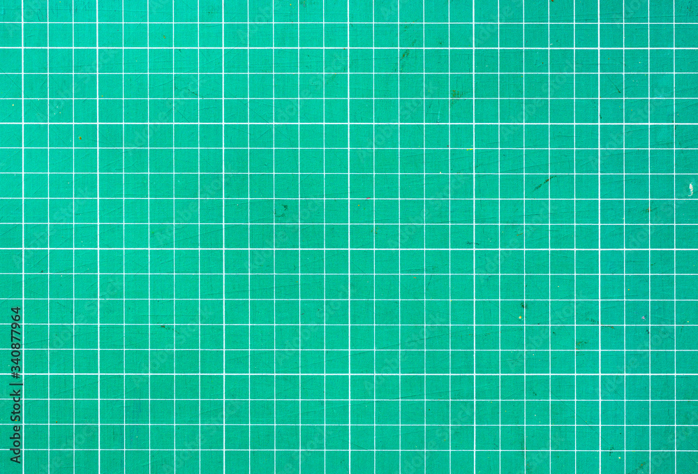 Wall mural plastic green cutting mat texture. squared sheet texture green background