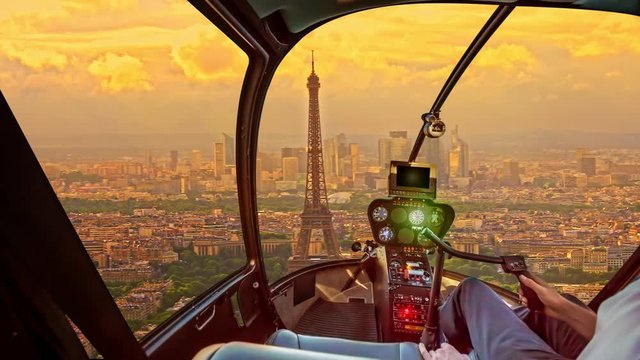 Helicopter cockpit interior flying on Tour Eiffel at sunset in Paris, France. Travel and tourism concept. Scenic flight above Paris skyline. Urban sunset aerial scene on blurred background.