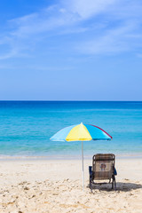 Relaxing by the beautiful beach, holiday and vacation destination to Paradise island in South of Thailand, beach chair under colorful umbrella with blue sea view and clear blue sky