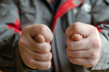 The man shows two fig gestures to the camera.