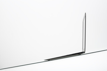 computer mouse with inverted laptop on inclined glass table surface isolated on white background  