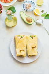 Obraz na płótnie Canvas Tasty tortilla wraps sandwiches with avocado and fresh vegetables ingredients on light table background, top view. Healthy food. Vegetarian lunch or snack