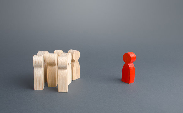 Red figurine person and crowd of people standing separately. Leader and leadership skills. Cooperation, collaboration. Fear estrangement from infected. Isolation, avoidance of direct contact. Mistrust