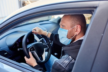 Man with protective mask adriving a car by Coronavirus pandemic quarantine