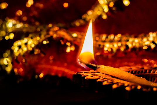 beautiful shining earthen lamp in front of blurred red chunari background. festival of lights