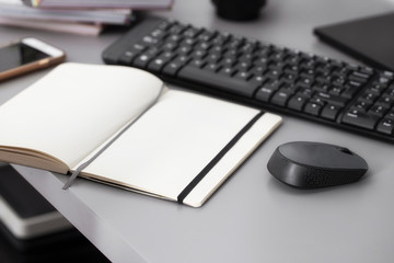 Open notepad with pen on the table with keyboard and computer mouse. Working space concept.