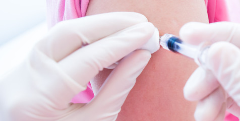 Doctor or nurses hand are adult vaccination to patient using the syringe injected upper arm for treated,Doctor giving an injection to a patient,Prophylactic HPV vaccin, flu, covid-19 and anal cancer.