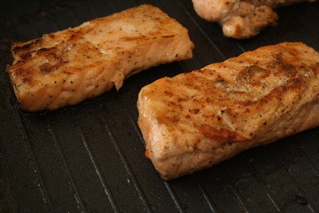 cooking food, fried pieces of fish in a grill pan