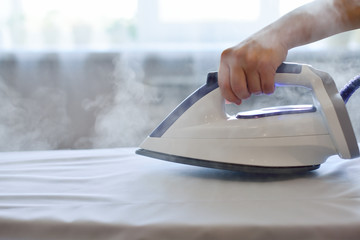 Girl ironing shirt with steam station