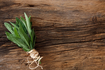 sage- bunch applies herbs on a wooden table - background