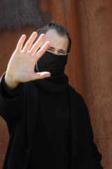 Handsome man wearing a mask on the streets of the city. Closeup of a young man in a respirator to protect against infection with influenza virus or coronavirus