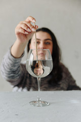 beautiful girl at the table with a wine glass with water and a paint brush