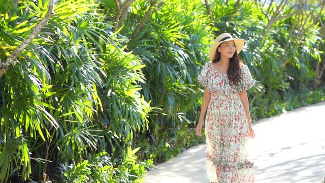Asian Woman in Long Dress Walking Happily in Sunny Hotel Garden SLOMO