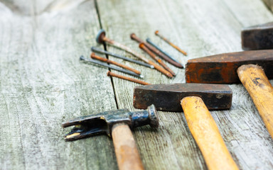 Set of vintage hand construction and carpentry tools hammers on a old wooden background, retro...