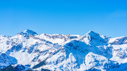 Fototapeta na wymiar Winter landscape with snow covered peaks on Kleine Scheidegg mountain in Swiss Alps near Grindelwald, Switzerland