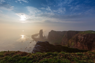 Helgoland, Long Anna, landscape with steep hillside at sunrise shrouded in morning mist and beautiful sea