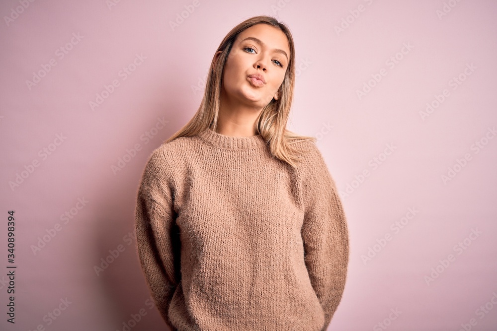 Sticker young beautiful blonde woman wearing winter wool sweater over pink isolated background looking at th