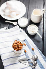 Fototapeta na wymiar almonds in a white porcelain Cup on the table with baking ingredients