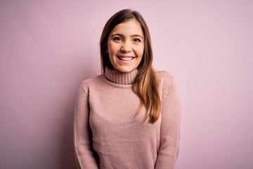 Fototapeta premium Beautiful young woman wearing turtleneck sweater over pink isolated background with a happy and cool smile on face. Lucky person.