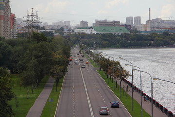 Moscow, Russia, Top view on Nagatinskaya embankment road traffic, cars, Moscow river and Nagatino area from Nagatinsky metro bridge at summer cloudy day