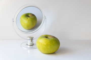 Apple reflection in the mirror on a white background