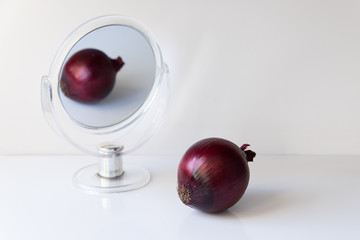 Onion reflection in the mirror on a white background
