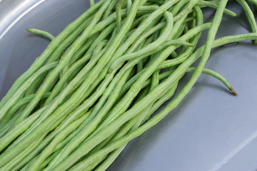 Yardlong beans fresh on dish.