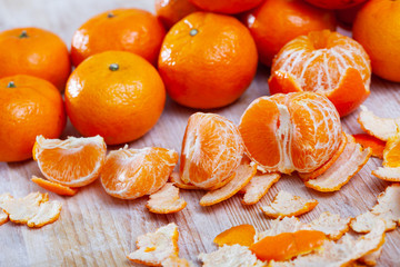 Ripe peeled  tangerines on wooden table in kitchen