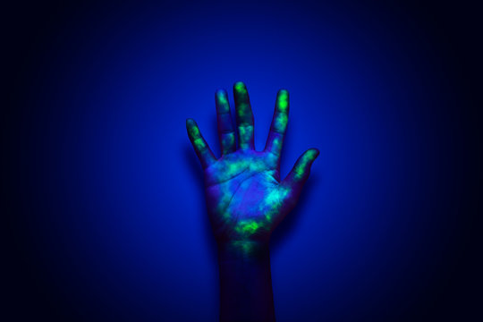 A Human Hand Under UV Light Review The Hidden Bacteria, Virus. An Idea, Conceptual Images.