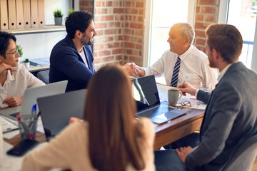 Group of business workers smiling happy and confident. Working together with smile on face shaking hands at the office