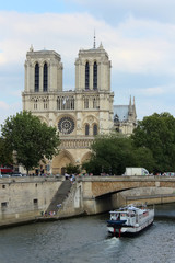 Fototapeta na wymiar Paris, France - August 26, 2018: Tourists enjoy a boat trip on Seine river near Notre Dame cathedral.