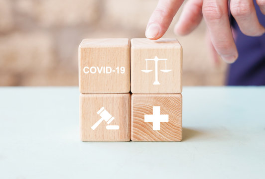 Doctor hand arranging wood block stacking with icon justice healthcare. Labor Law Lawyer Legal Concept in medical on the theme of coronavirus.
