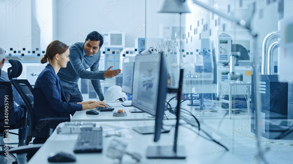 Poster inside factory office: male project supervisor talks to a female industrial engineer who works on co