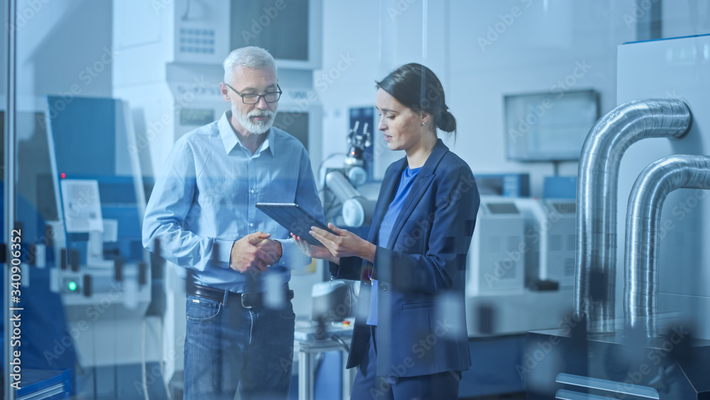 Poster modern factory: female engineer, male project manager standing in high tech development facility, ta