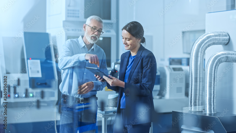Poster modern factory: female engineer, male project manager standing in high tech development facility, ta