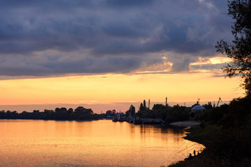 Colorful clouds at sunset over the river in the town