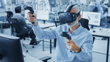 Industrial Design Engineer Wearing Virtual Reality Headset and Holding Controllers, Uses VR...