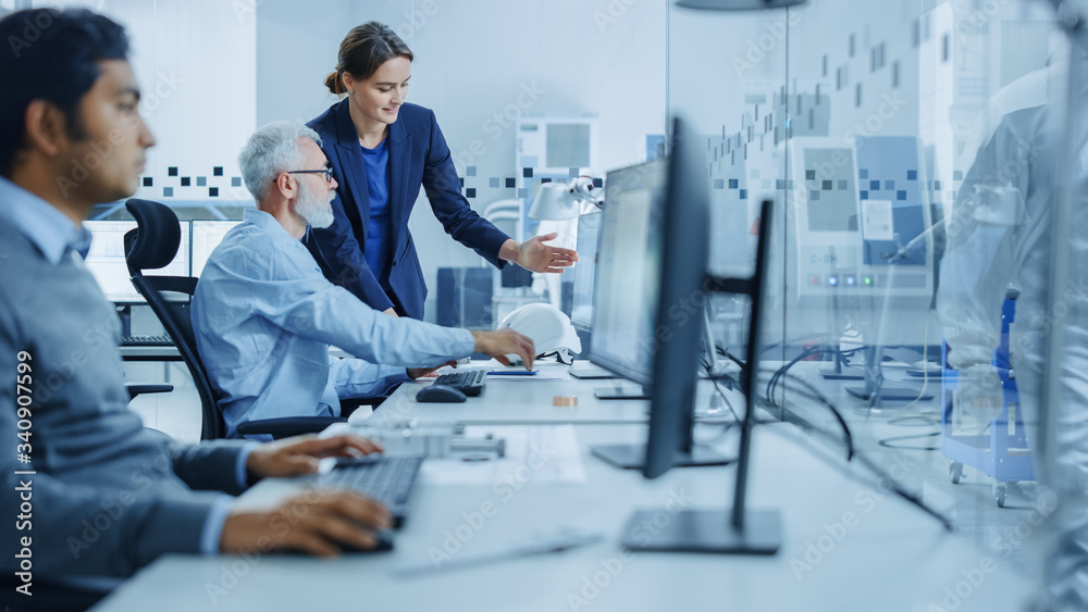 Poster inside factory office: female project supervisor talks to male senior industrial engineer who works 