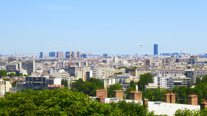 Fototapeta na wymiar Paris, France - August 26, 2019: Paris from above showcasing the capital city's rooftops, the Eiffel Tower, Paris tree-lined avenues with their haussmannian buildings and Montparnasse tower. 16th