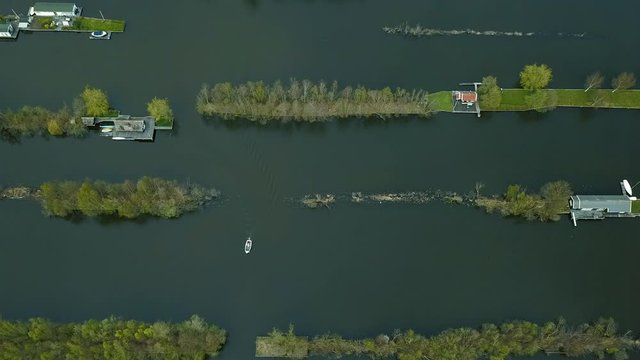 Aerial footage of recreational harbor for small boats and bungalows on small islands in a lake in the Netherlands