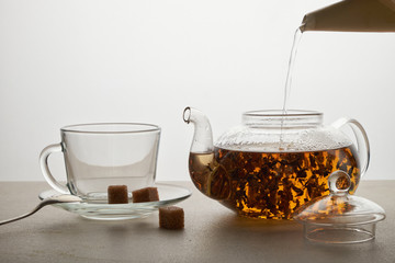 Cup and teapot of green tea with lemon and sugar isolated on white