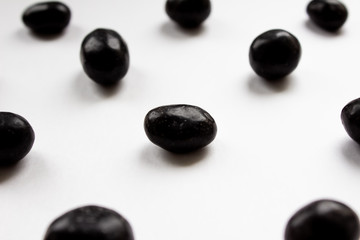 Chocolate coated peanuts on a white background, close-up