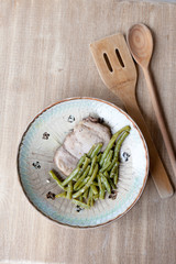 Chicken breast with green peas in rustic plate
