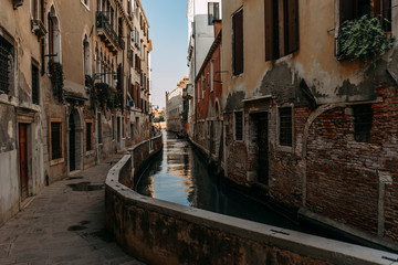 Fototapeta na wymiar Narrow streets of Venice with tall houses made of wild stone and a single street lamp where the locals live | VENICE, ITALY - 16 SEPTEMBER 2018. 