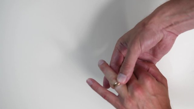Man puts a wedding ring on his finger. Close up