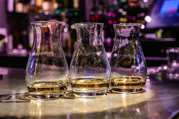 Flight of Scottish whisky, tasting glasses with variety of single malts or blended whiskey spirits on distillery tour in pub in Scotland