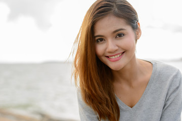 Young beautiful Asian woman against scenic view of the lake