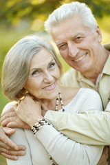 Smiling senior couple embracing in autumn park