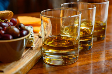 Flight of Scottish whisky, tasting glasses with variety of single malts or blended whiskey spirits on distillery tour in pub in Scotland