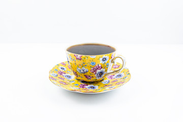 Tea cup with tea inside on the white table